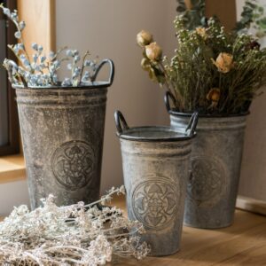 Vases en fer forgé de style antique avec motif gravé. il est disponible en grand format pour contenir des bouquets volumineux.