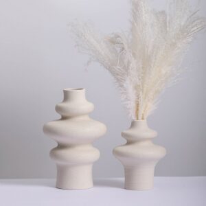 Vases blancs en céramique style scandinave avec bouquet de pampa. Le design est d'influence scandinave, avec des courbes minimalistes.
