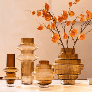Vase en verre ambré de forme géométrique, avec reflets marron. Un vase en forme tubulaire et l'autre en forme sphérique original. Ils sont de design moderne et intègre un bouquet de fleurs séchées.