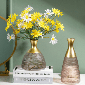 Vase de style art déco en forme de jarre en verre de teinte mauve. Sa forme évasée et son col doré lui donnent un style antique et prestigieux. Il est exposé avec un bouquet de fleurs jaunes.