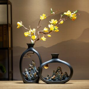 Vase japonais noir de forme arrondie et ajourée dans un style zen traditionnel. Dans son centre est sculpté un motif de montagne typique des paysages japonais. Il contient une fleur jaune en soliflore.