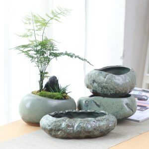Vase japonais en céramique style jardin zen. Il reproduit la forme d'un petit rocher, de forme plat et évasé. Sa peinture est un mélange de bleu et de gris. Il est idéal pour exposer vos fleurs en extérieurs et apporter un style relaxant à votre décor.