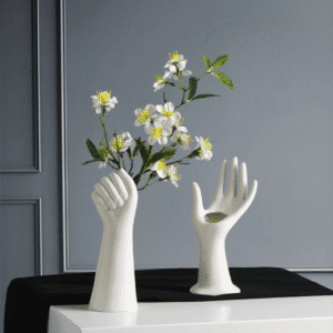 Vase blanc moderne en céramique. Il est modelé de manière originale et reproduit la forme d'une main humaine.