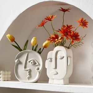 Vase moderne en céramique, représentant un visage de style cubique, à la Picasso. Ce vase blanc contient des tulipes jaunes et des marguerites oranges.