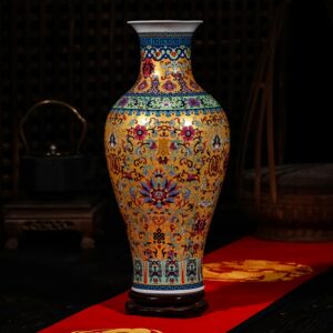 Grande jarre chinoise en porcelaine. C'est un vase exceptionnel, fabriqué en porcelaine, dans des couleurs à dominantes doré, avec des motifs traditionnels multicolore : vert, rouge, bleu… Le vase est brillant. Il est disposé sur un tapis rouge. L'arrière-plan est sombre.
