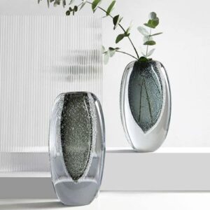 Deux vases de style Murano en verre épais à double paroi. Le cœur du vase est teinté en gris et finement bullé. Il y a un grand vase et un modèle plus petit qui contient une branche de plante verte.