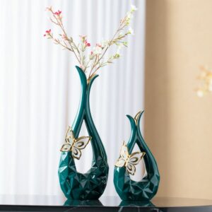 Vase original en forme de goutte, de couleur vert, agrémenté d'un petit papillon sculpté sur sa base. Le vase est ajouré, il laisse passer la lumière en son centre. Exposé en deux formats, petit ou grand, ce vase est unique en son genre. Il peut être utilisé pour exposer une seule fleur ou un bouquet coloré.