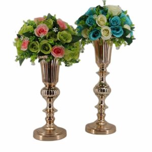 Grand vase en forme de coupe dorée d'inspiration Médicis. Ils contiennent des bouquets de roses blanches, bleues et roses.