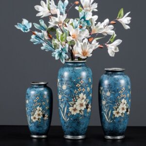 Vase vintage bleu à motifs floraux. Ce trio de vase est disponible en trois formats différents. Le plus grand format contient un bouquet de fleur blanches et bleues. Le style en amphore est traditionnel et apporte un design classique à votre intérieur pour sublimer vos fleurs.