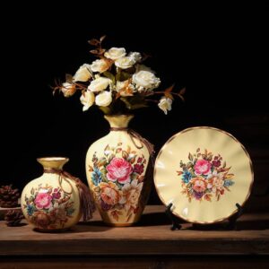 Vase vintage exposé en trio constitué de deux vases et d'une assiette aux motifs similaires et harmonieux. Ce jeu de trois pièces apporte une homogénéité et un style unique dans votre décoration intérieure. Accordez-les avec des fleurs de couleurs semblables ou crée un contraste pour accentuer l'allure de ces vases.