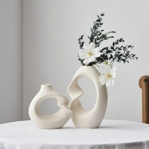Vase blanc style nordique en duo. Ces deux vases de forme géométrique abstraite sont conçus dans un style épuré et moderne. Apportez une touche de design en exposant un bouquet de fleurs séchées ou une belle rose en soliflore.