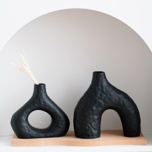 Vase noir style nordique en duo. Ces deux vases de forme géométrique abstraite sont conçus dans un style épuré et moderne. Apportez une touche de design en exposant un bouquet de fleurs séchées ou une belle rose en soliflore.