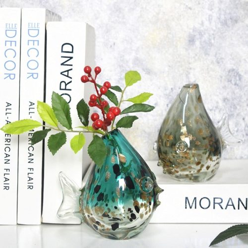 Vase en verre soufflé d'inspiration Murano. Il a la forme d'un poisson lune, arrondi. Il est disponible en vert, bleu et gris. Un magnifique petit soliflore.